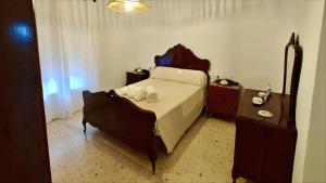 een slaapkamer met een bed en twee nachtkastjes en een tafel bij Villa Bellavista in Olvera