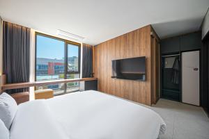 a bedroom with a large bed and a tv at 대구 동성로 호텔 에이유 in Hyomoktong-Ilgu