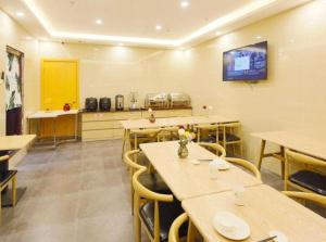 a room with tables and chairs in a restaurant at GreenTree Inn Shanghai Railway Station Macao Road in Shanghai