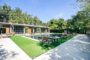 a patio with tables and chairs next to a pool at OYO 75374 Baan Rak Mai in Ban Lum Makok