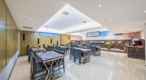 a dining room with tables and chairs in a building at Lavande Hotels Harbin Shimao Avenue Wanda in Harbin