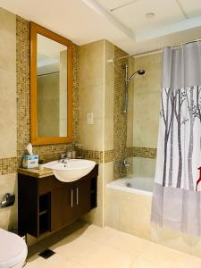 a bathroom with a sink and a toilet and a tub at Greens in Dubai +33 photos