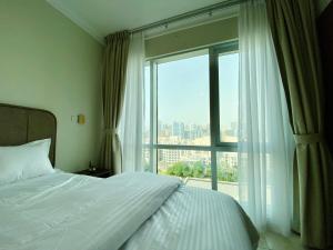 a bedroom with a bed and a large window at Greens in Dubai