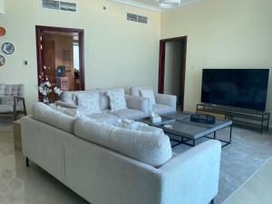 Una sala de estar con un sofá y una mesa de café. en 2BR Beachfront Apartment with Ocean Views, en Ajman