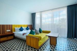 a bedroom with a bed and a couch and a window at K.K inn Boutique Siem Reap in Siem Reap