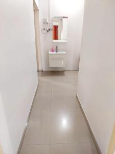 une salle de bain blanche avec un lavabo et un miroir dans l'établissement Muktangan Home, Kolhapur, à Kolhapur