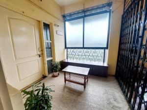 une chambre avec un banc devant une fenêtre dans l'établissement Muktangan Home, Kolhapur, à Kolhapur