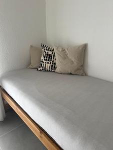 Una cama con dos almohadas encima en una habitación. en Living Lu - cosy Apartment one - Netflix - Mannheim - BASF - 1 Zimmer, en Ludwigshafen am Rhein