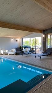 - une piscine dans une maison avec une terrasse en bois dans l'établissement La villa Grand Ouest, à Plounéour-Trez
