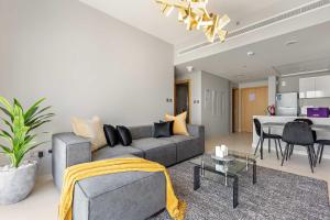 un salon avec un canapé gris et une table dans l'établissement Silkhaus Stylish 2BDR Stay in Radiant Boulevard, à Mushayrib