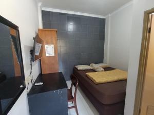 a small room with a bed and a desk at JJ House Kost Exclusive Nologaten in Yogyakarta
