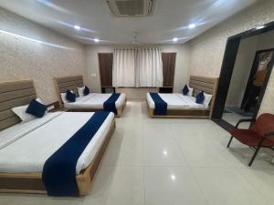 a hotel room with two beds and a red chair at Khatu Bagh Resort in Sīkar
