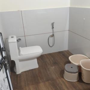 a white bathroom with a toilet and a shower at Rann Riders in Rāpar