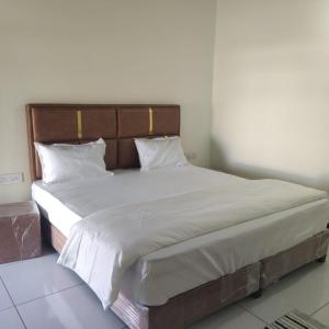 a large bed with white sheets and pillows at Rann Riders in Rāpar