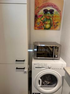 Un microondas y una lavadora en una cocina. en Living Lu - cosy Apartment one - Netflix - Mannheim - BASF - 1 Zimmer, en Ludwigshafen am Rhein