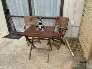 a wooden table with two bottles and two glasses of wine at Sea La Vie in Cable Bay