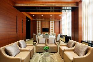 a dining room with chairs and tables and a table at New World Wuhan Hotel in Wuhan