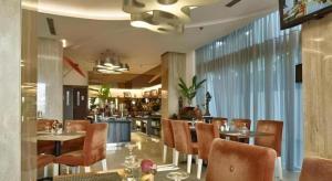 a dining room with tables and chairs in a restaurant at d'primahotel Mega Kuningan in Jakarta