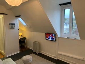 a room with a tv on a wall with a window at 45 Grande Rue bis in Ault