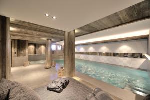 a swimming pool in a building with a large pool at Chalet My World in Combloux