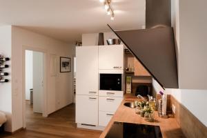 a kitchen with white cabinets and a counter top at Appartement Hauser Kaibling in Haus im Ennstal