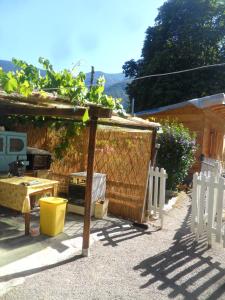 un patio trasero con pérgola de madera, mesa y sillas en La vieille maison Biselli, en Tende