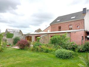 a brick house with a garden in the yard at Coriandre La Tisanerie 1 room apartment et lits d appoint in Condé-sur-lʼEscaut