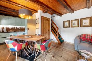 een keuken en woonkamer met een houten tafel en stoelen bij Nini's Home in Schignano