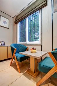 a living room with a table and chairs and a window at JS Residency Luxe Collection Hotel Near Nizamuddin Railway Station in New Delhi