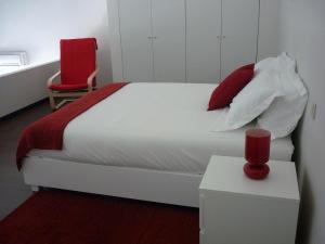 - une chambre avec un lit blanc et une chaise rouge dans l'établissement 12 Short Term, à Porto