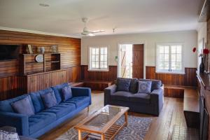 a living room with two blue couches and a coffee table at Fairbridge Village in Pinjarra
