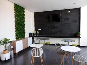 une pièce avec deux tables et des chaises et un mur dans l'établissement Tropical Point Hotel Syariah, à Pipulu