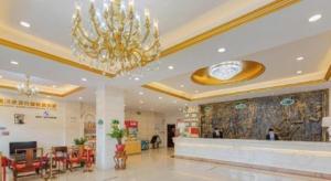 a lobby of a shopping mall with a chandelier at Vienna Hotel Meizhou Mei County Airport in Meizhou