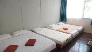 a room with three beds with red napkins on them at Mari Mari Sepanggar Lodge in Kota Kinabalu