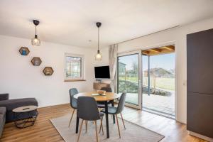 une salle à manger et un salon avec une table et des chaises dans l'établissement Ferienwohnung Alpenvorland, à Seeg