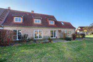 ein großes Backsteinhaus mit einem roten Dach in der Unterkunft Haus Herr Krug in Walkendorf