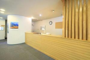 a lobby with a wooden counter in a building at Kamikochi Taishoike Hotel in Matsumoto