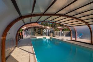 einen Blick über einen Pool mit Torbogen in der Unterkunft Maison Tournesol in Escloux