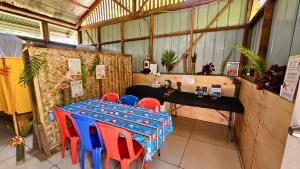 Kelly's home stay في جوروكا: غرفة بها طاولة وكراسي حمراء وزرقاء