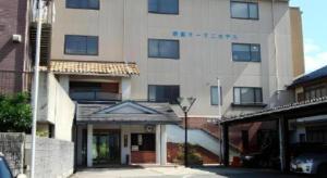 a building with a parking lot in front of it at Sento Otani Hotel in Toyooka