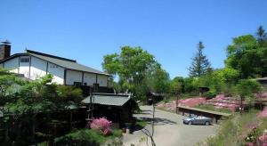 a house with a car parked in a parking lot at Auberge Kitano Dandan in Abashiri