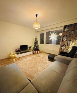 a living room with a couch and a christmas tree at Cozy apartment in Rovaniemi! in Rovaniemi