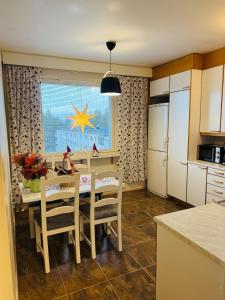 a kitchen with a table with chairs and a dining room at Cozy apartment in Rovaniemi! in Rovaniemi