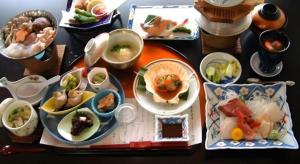 a table with plates of food and bowls of food at Hotel New Katsura in Sado
