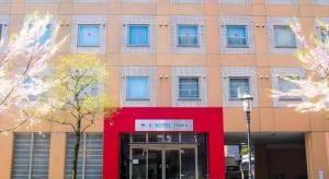 a building with a red front with a sign on it at AI HOTEL OYAMA in Oyama