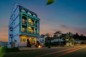 a large building with lights on in a street at Bee Luxury Dalat Hotel in Da Lat