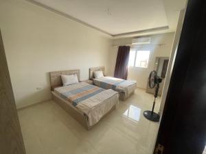 ein Hotelzimmer mit zwei Betten und einem Fenster in der Unterkunft Marvel lotus in Hurghada
