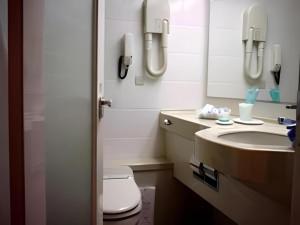 a bathroom with a sink and a toilet and a mirror at Matsuyama City Hotel in Matsuyama