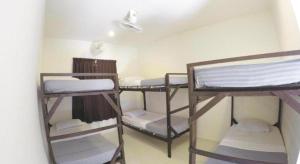 une chambre avec trois lits superposés dans une pièce dans l'établissement Perhentian Tivoli Inn, à Kampong Pasir Panjang