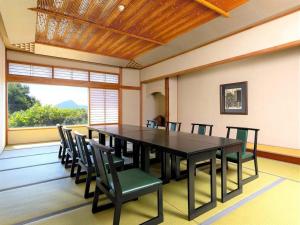 a dining room with a black table and chairs at Yukemuri no sato azumaya in Beppu